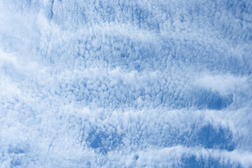 Blue sky and thin striped white cloud layer as a nature background
