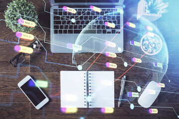 Double exposure of map hologram drawing over study table background with computer. Concept of international network. Top view.