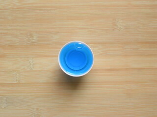 Top view of blue color Mouthwash liquid in round measuring cup