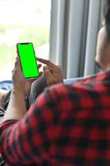 Man at Home Uses Green Mock-up Screen Smartphone.