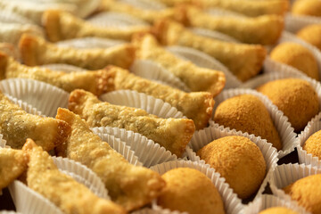 Brazilian gastronomy. Various snacks, such as pastries, chicken drumsticks and risoles.