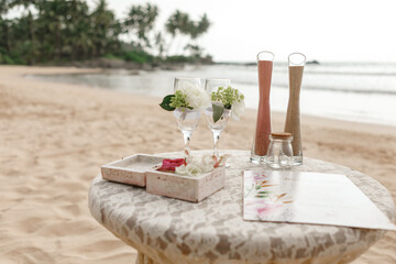Closeup view of elements of wedding sand ceremony. Two bottles with decorative pink and white color sand ready for pouring in one vase as symbol of unity. Horizontal color photography
