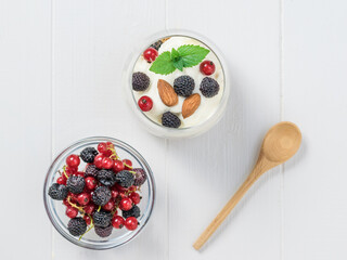 Milk, almonds and granola in a clay bowl on a wooden table.