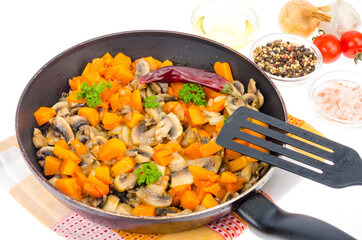 Vegetarian vegetable stew of pumpkin and mushrooms in pan, white background.