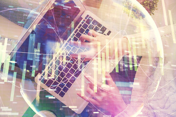 Double exposure of woman hands working on computer and financial theme hologram drawing. Top View. Business concept.