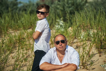 Portrait of a father by his son on a summer walk in nature . Father's day