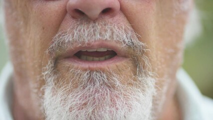 Close up of senior mans mouth talking to camera 