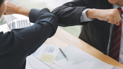 Happy office workers Smiling in face mask elbow bumping with protection of coronavirus.