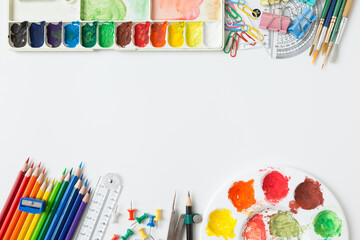 Top view of Colorful Watercolor palette, paintbrush, colored pencils, ruler and drawing equipment  on white background and copy space