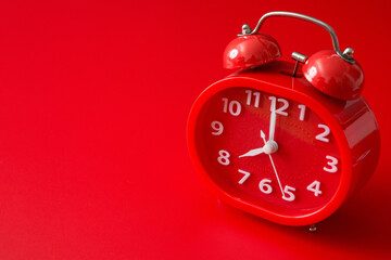 red alarm clock  on a red background and copy space