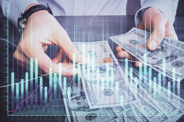 Multi exposure of financial graph drawing hologram and USA dollars bills and man hands. Analysis concept.