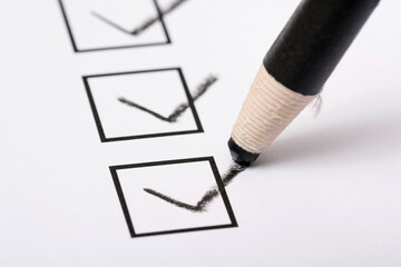 Checklist and pencil close-up on white background
