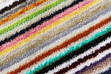 Texture of a multicolored tabby carpet. Abstract striped background.