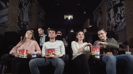 Young people laugh at comedy movie in cinema theatre. Young people laughing at cinema watching amusing comedy.