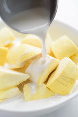 Thai dessert, sliced durian fruit in a bowl eating with coconut milk