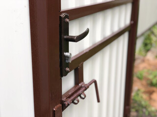 Metal profile wicket with a lock, handle and latch in the courtyard of a private house