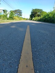 Yellow line in poor condition on asphalt road texture background. Damaged Asphalt road texture with yellow line.