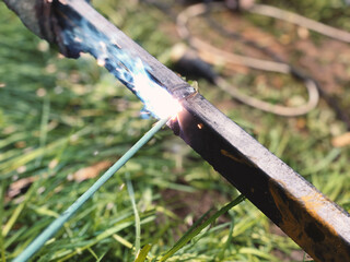 Electric welding of two metal structures on the street during the day