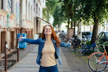 Fototapeta na wymiar Happy young woman rejoicing with outstretched arms