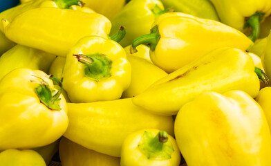 Solid background of fresh ripe and natural yellow peppers