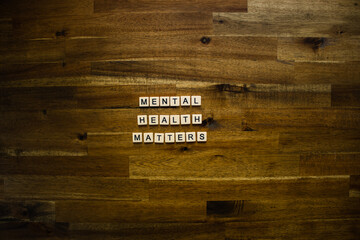 Flat lay photography - Word/s made with lettered tiles on timber background.