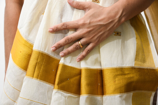 Indian silk sari, handmade white Kerala Sari, woman wearing holding sari, traditional wear on Onam festival, Vishu, wedding in India. multi-colored saree clothing.