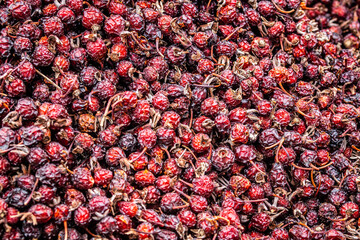 Solid background of fresh ripe and natural dried rose hips