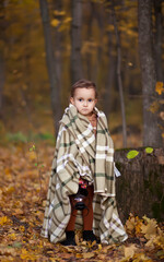 Fototapeta na wymiar Little girl on a brown coat and warm plaid holds lamp outdoors. Autumn time. Happy child playing at fall nature background. Autumn mood. Kids autumn fashion. Happy childhood.