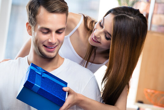 Portrait image of happy excited smiling couple with gifts boxes, at home. Shopping, sales, holidays love, relationship concept - young man and woman posing together, indoos.