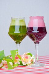 Two glasses of cold drinks with strawberries on a white background. Fruit smoothie, fresh juice. Healthy eating concept.