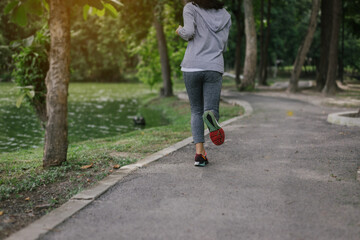 Fototapeta premium Behind young woman jogging at the park.relax concept.