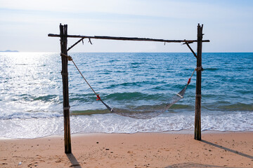 Romantic cozy hammock on the tropical beach by the sea. Peaceful seascape. Relax, travel concept, travelling.