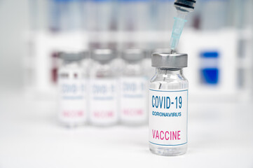 Medical concept. Syringe and covid-19 vaccine ampoule in a white background.
