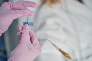 Skilled beautician with plastic catheter in hands