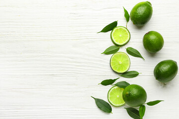 Ripe limes on white wooden background