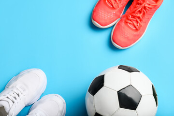 Soccer ball and shoes on color background