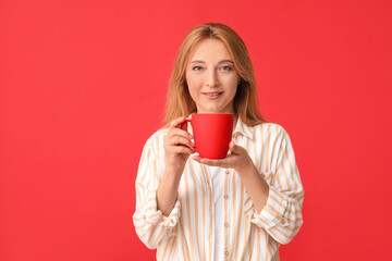 Beautiful woman with cup of tea on color background