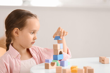 Little girl with autistic disorder playing with blocks at home