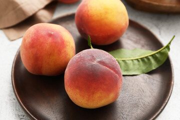 Plate with ripe peaches on table
