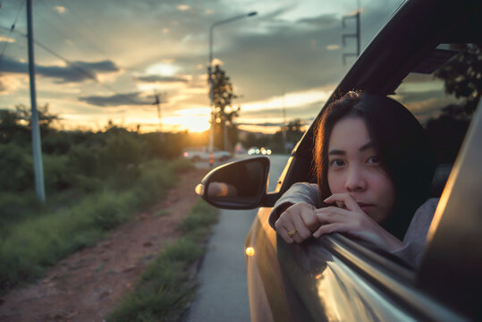 Smiling Woman Looking Out Of Car Window Enjoying Road Trip,Woman With Head Out Of The Window Of A Car.