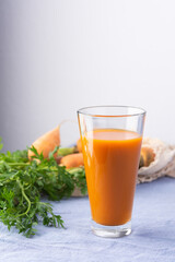 Natural carrot juice with pulp sugar-free in glasses on a table with a blue tablecloth