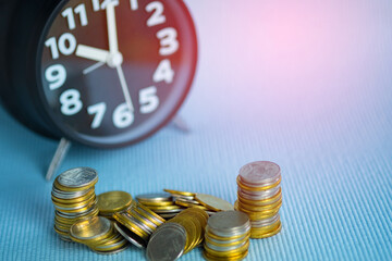 Stacks of coin with alarm clock with copy space, time for savings money concept, banking and business. shallow focus.