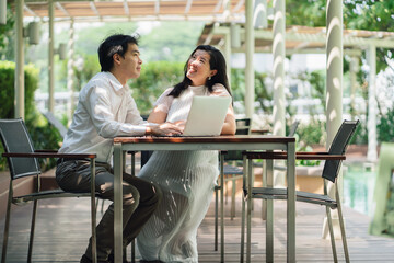Fototapeta premium Photos of Asian couple, husband, looking for information on looking after their first child and relaxing by the pool.