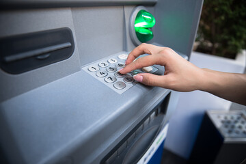 Hand entering personal identification number on ATM