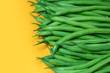 Green beans on a yellow background. copy space.