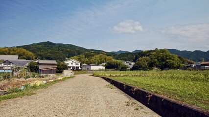 Fototapeta na wymiar June 2, 2020, early summer in Japan, a lone road and blue sky landscape in a rural village deep in the mountains