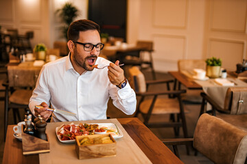 Fototapeta na wymiar Successful man enjoying delicious meal at luxurious restaurant, portrait.