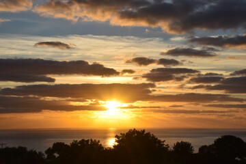 Fototapeta na wymiar Beautiful sunset landscape above the sea, orange sky with sun shining and clouds