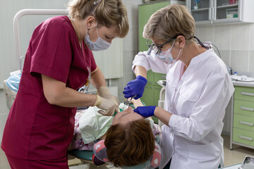Doctor and nurse in the dental office. The patient receives treatment.