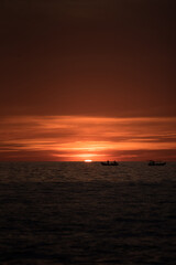 Fototapeta na wymiar A vibrant and beautiful sunset and fisher man 